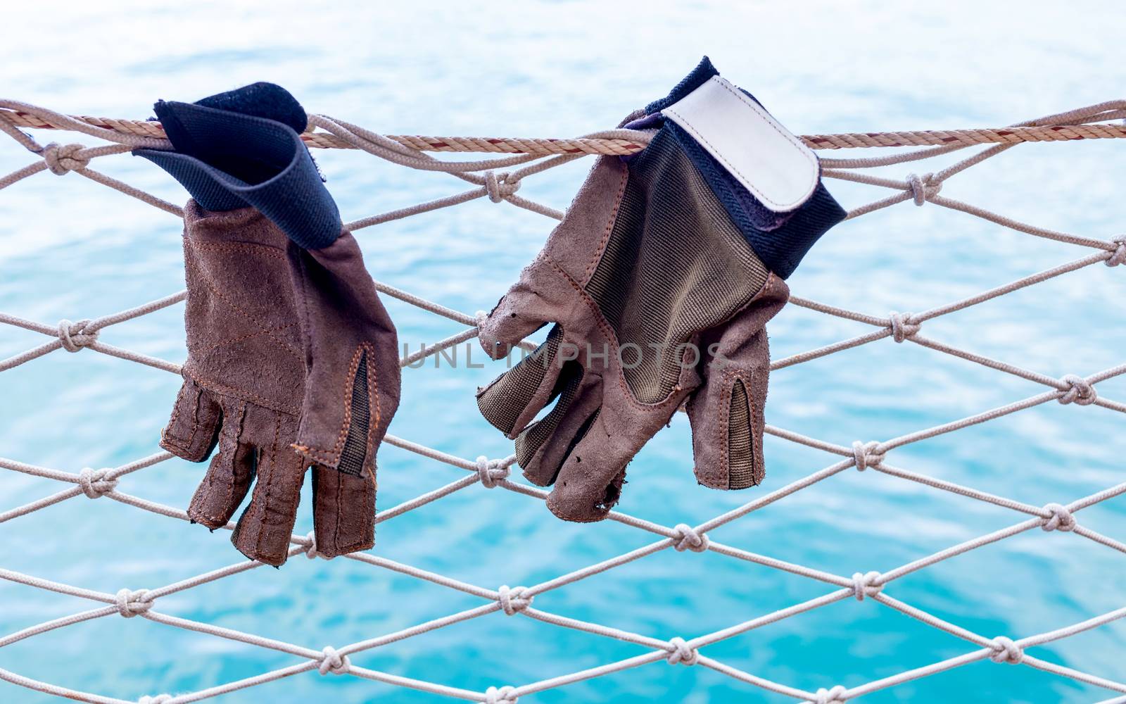 Sailing glove hanging on the nets  of sailing yacht.