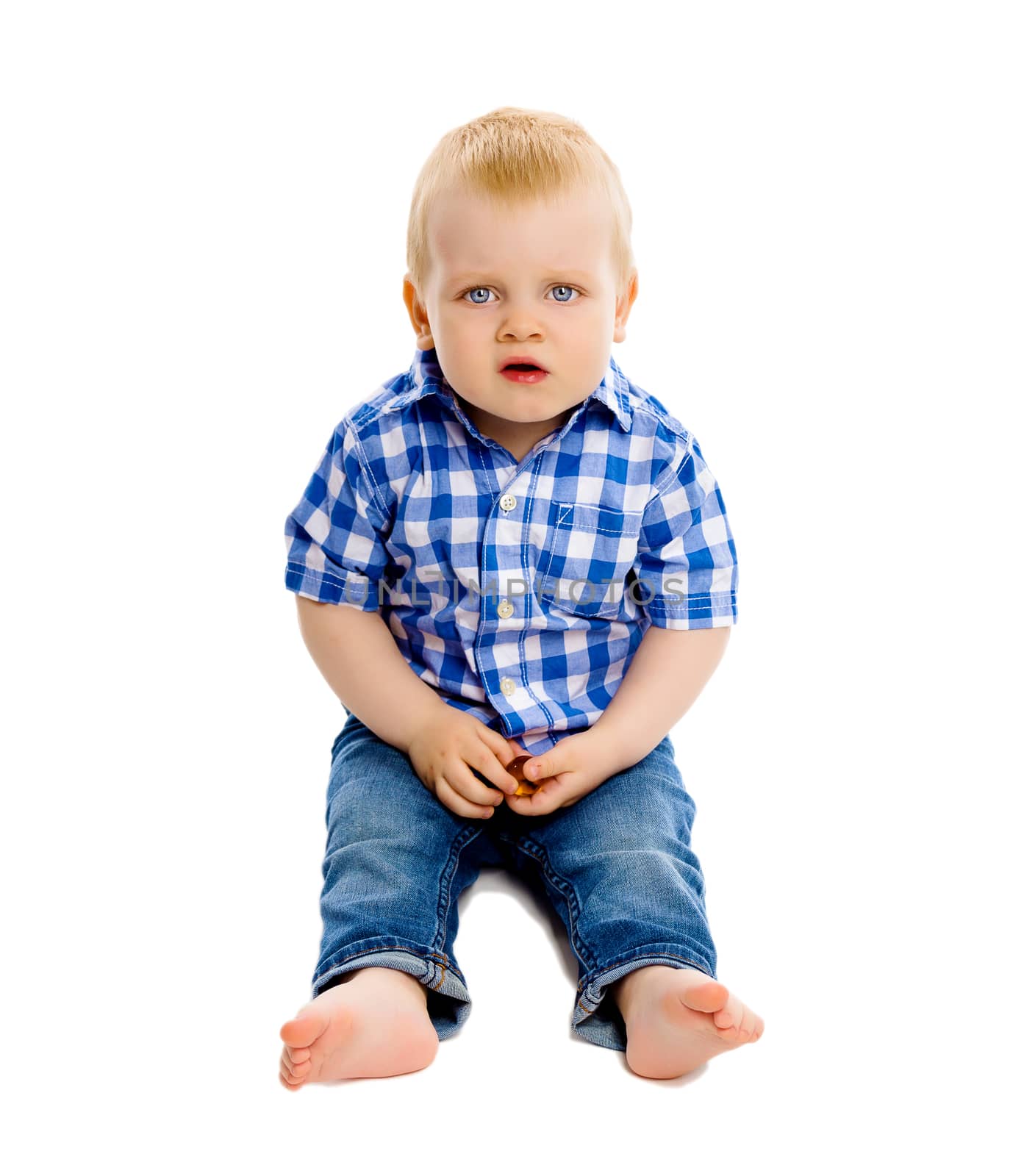 Little dissatisfied boy in a plaid shirt and jeans on white background