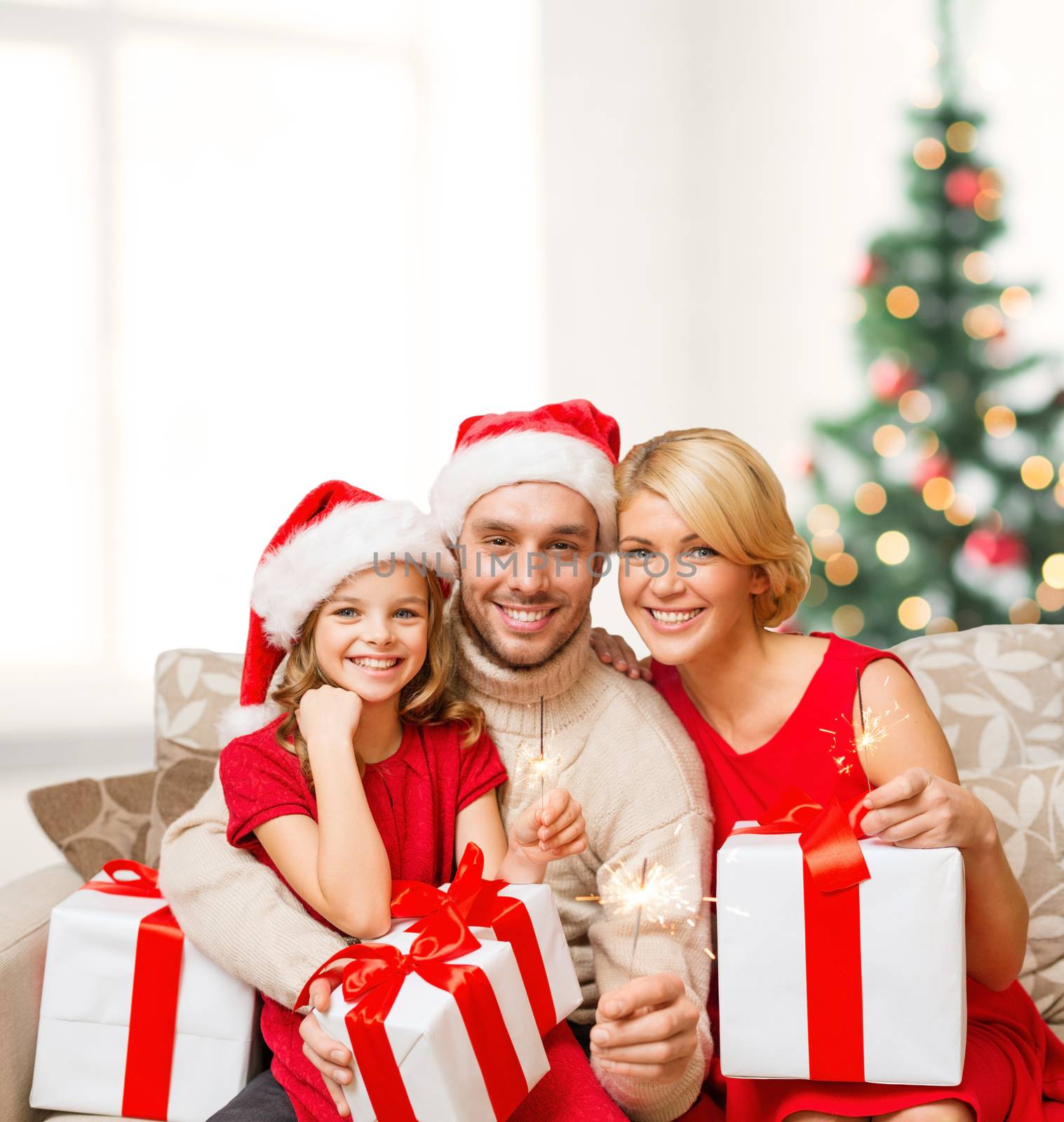 family, christmas, x-mas, happiness and people concept - smiling family in santa helper hats with many gift boxes and bengal lights