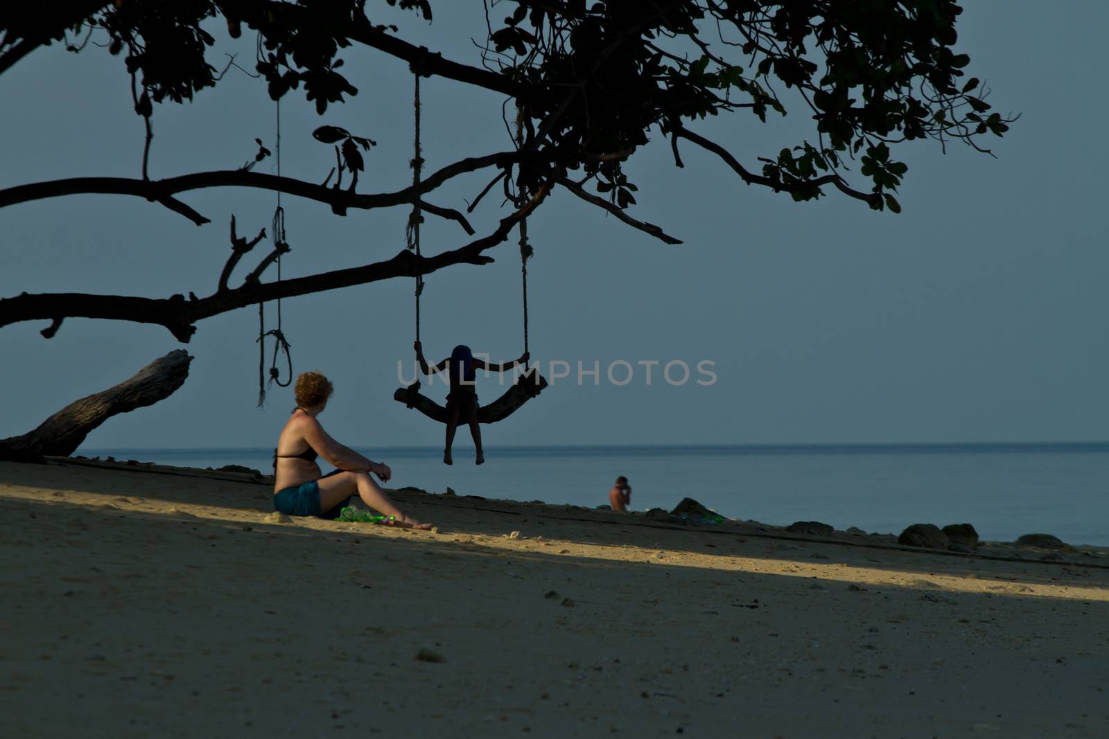 Child on a rudimentary swing at the beach in thailand during the summer