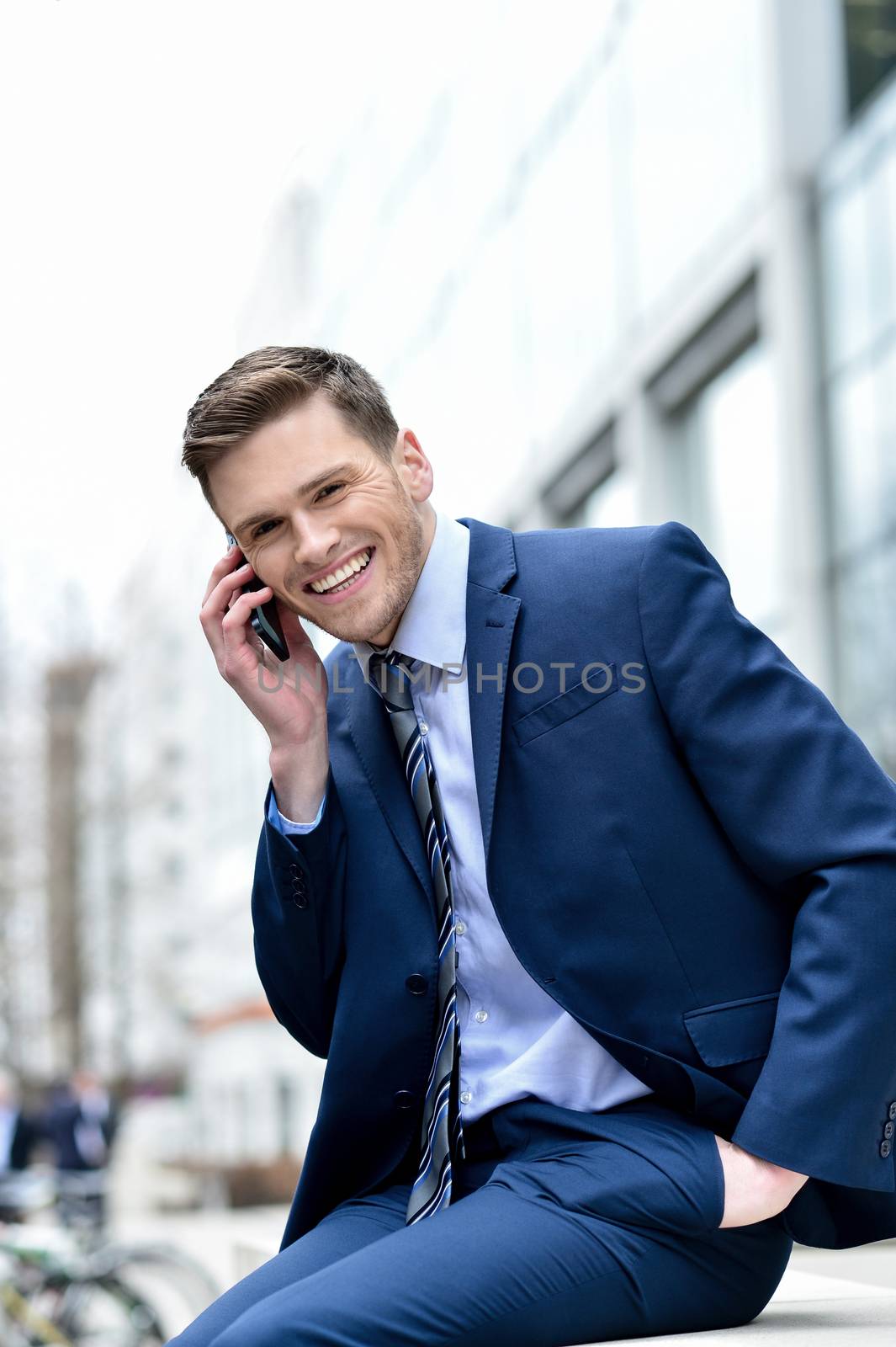 Image of a cheerful businessman talking on his cell phone