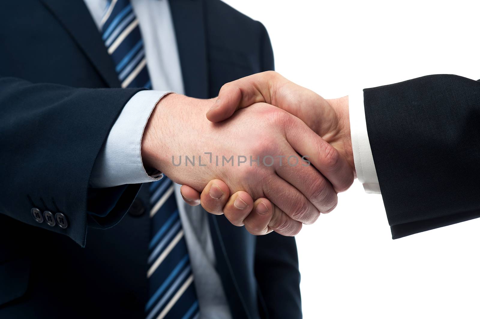 Cropped image of businessmen handshaking over white