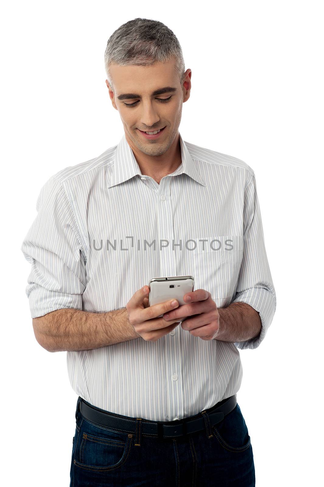 Casual guy operating his mobile phone over white