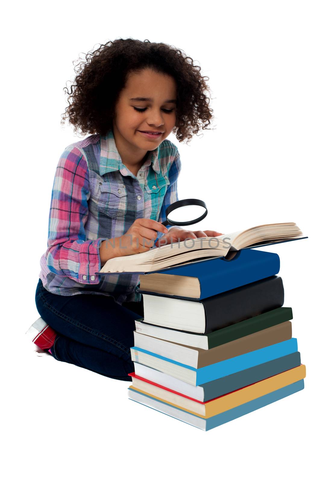 Little girl reading a book using magnifying glass