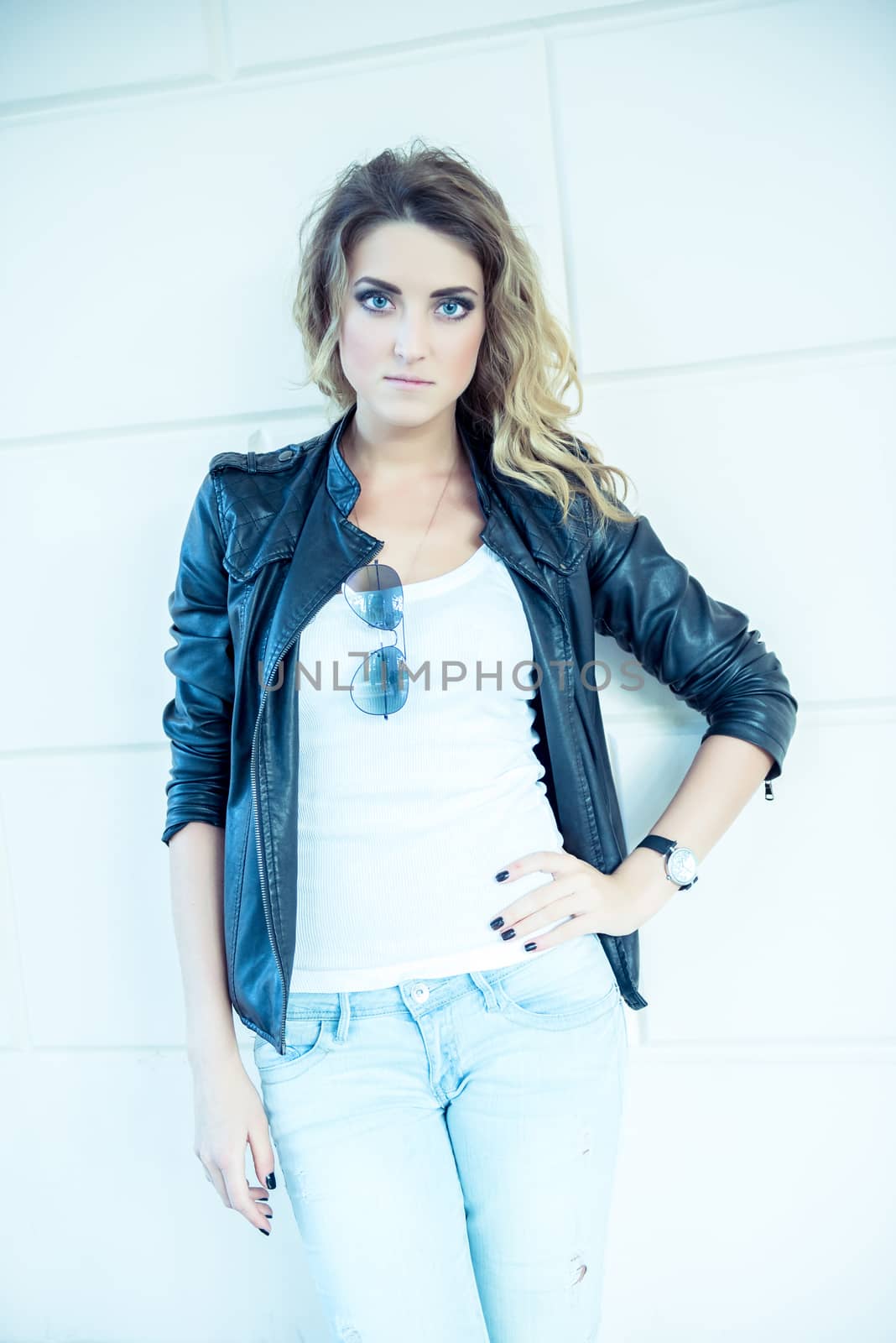 Hipster beautiful girl in leather jacket and jeans. Fashion girl posing with leather jacket