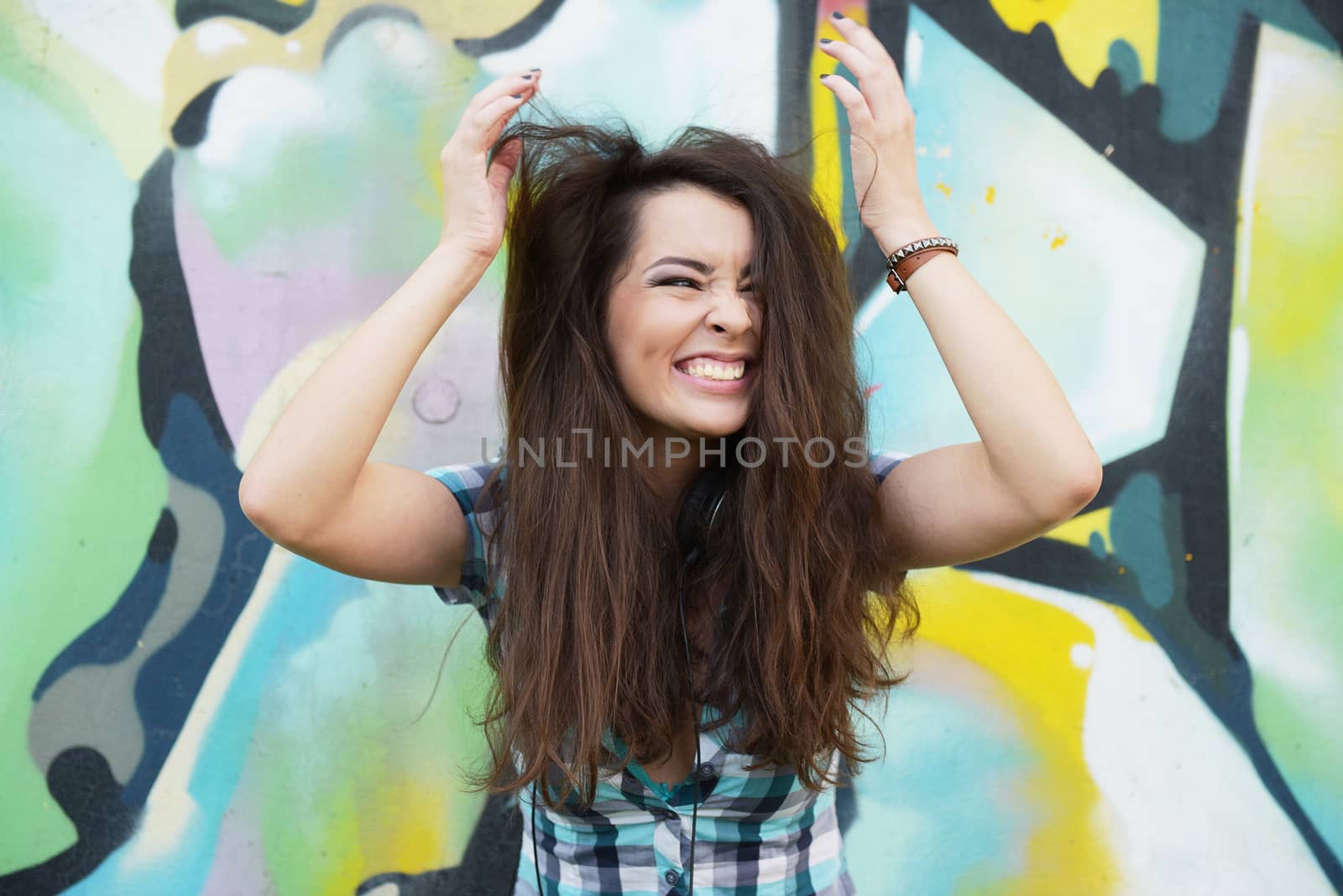 Portrait of young woman sitting at graffiti wall by shesaysboo