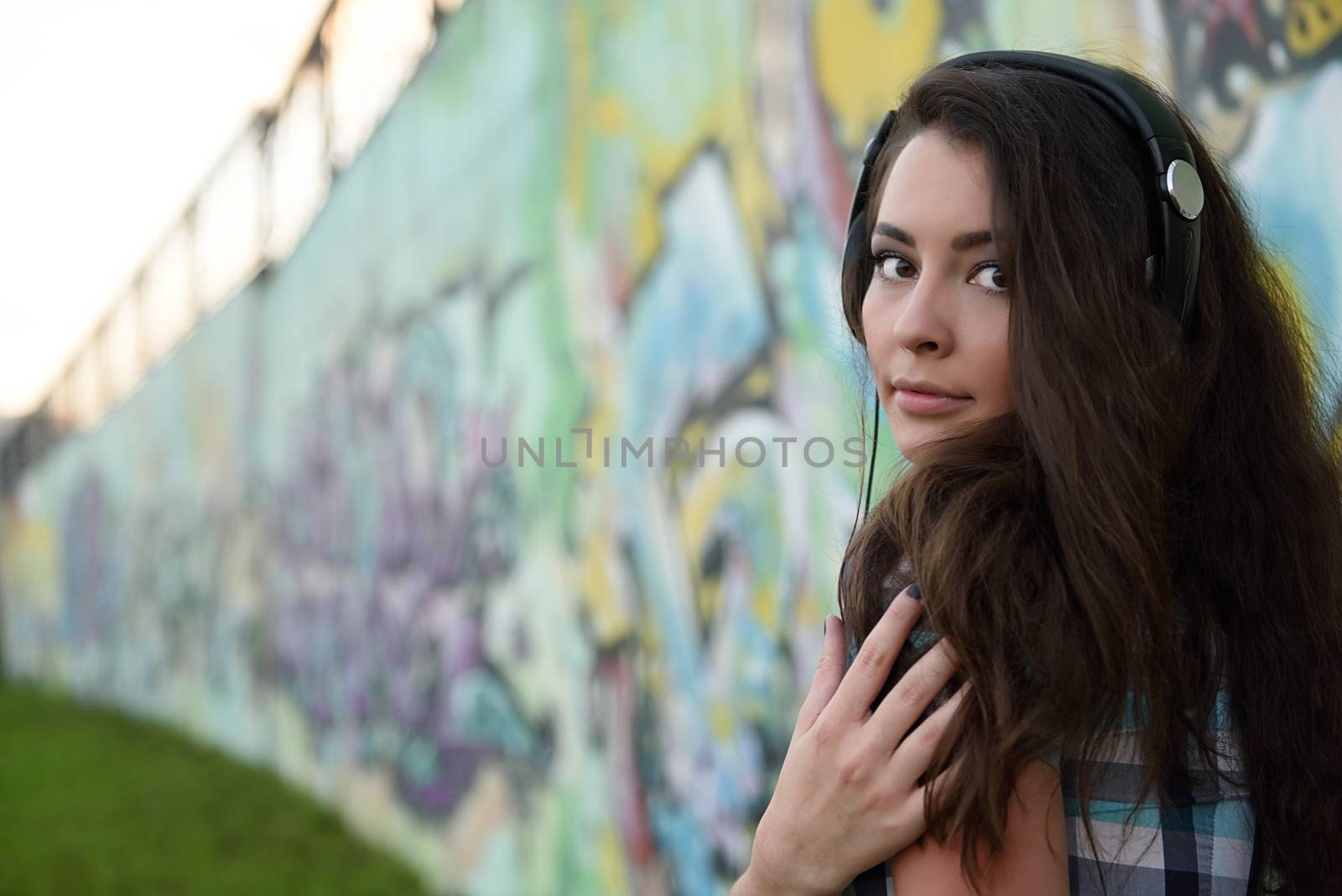 Portrait of young woman sitting at graffiti wall by shesaysboo