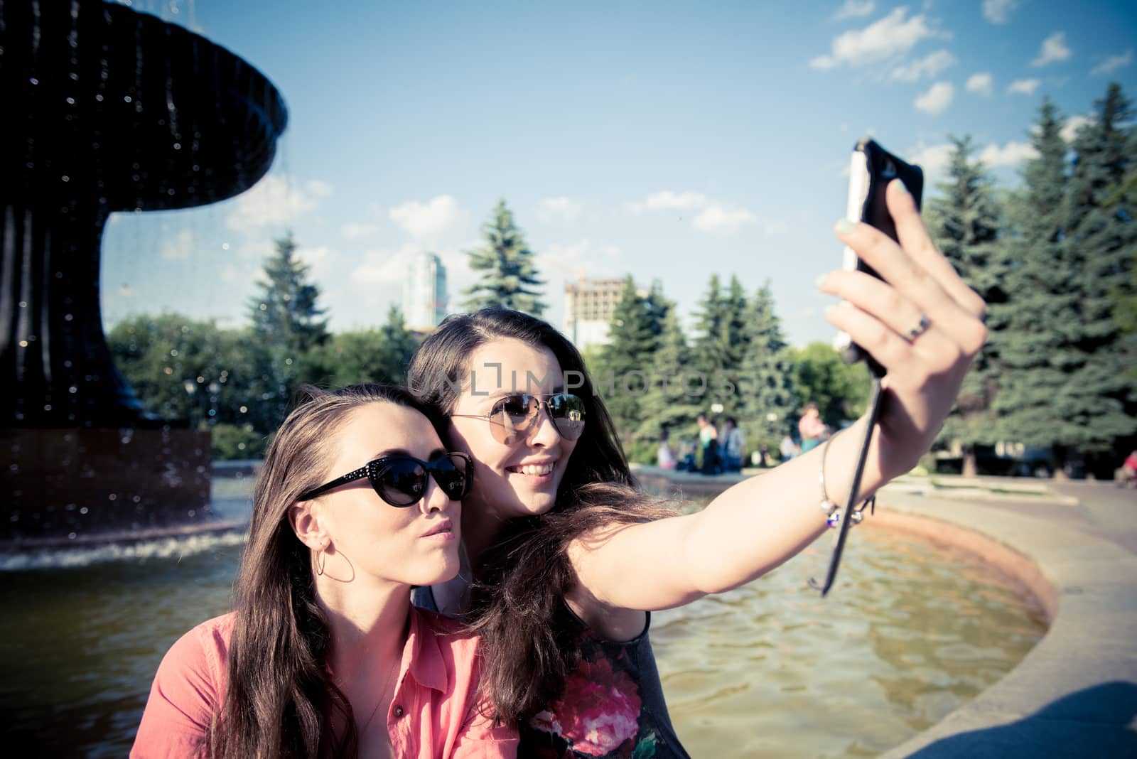 Two young women taking a selfie outdoors in summer