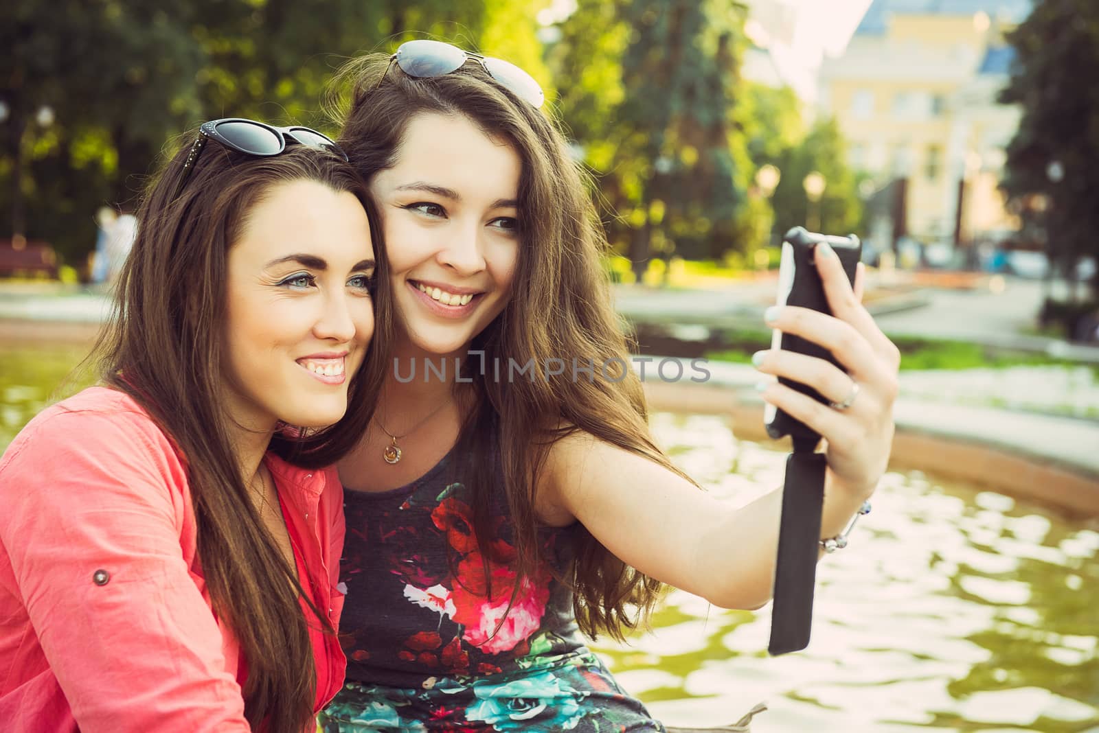 Two young women taking a selfie outdoors in summer