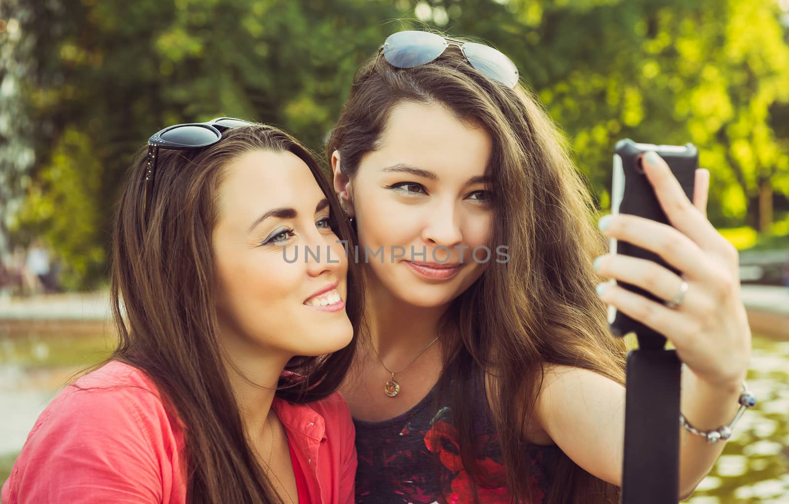 Two young women taking a selfie outdoors in summer