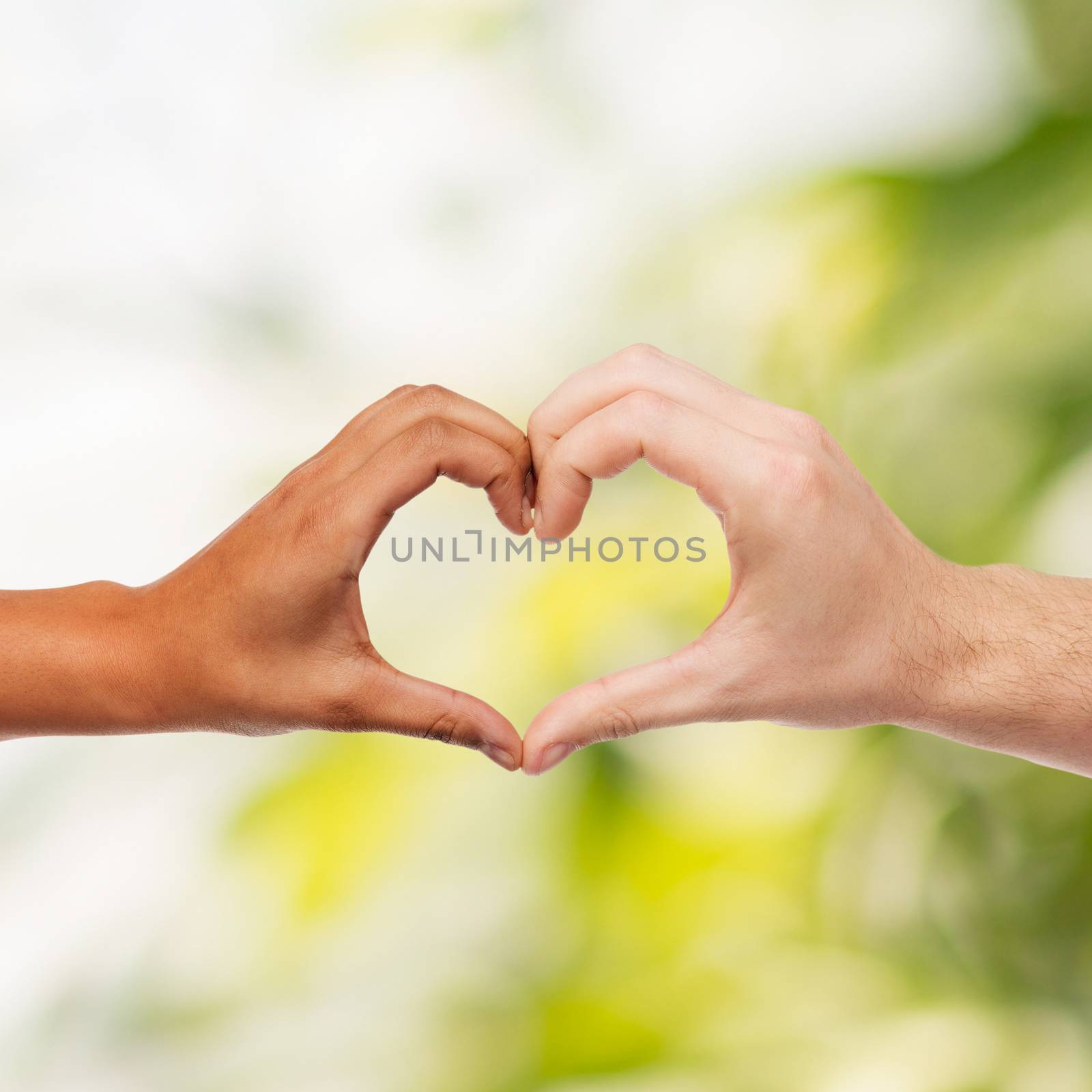 love and relationships concept - closeup of woman and man hands showing heart shape