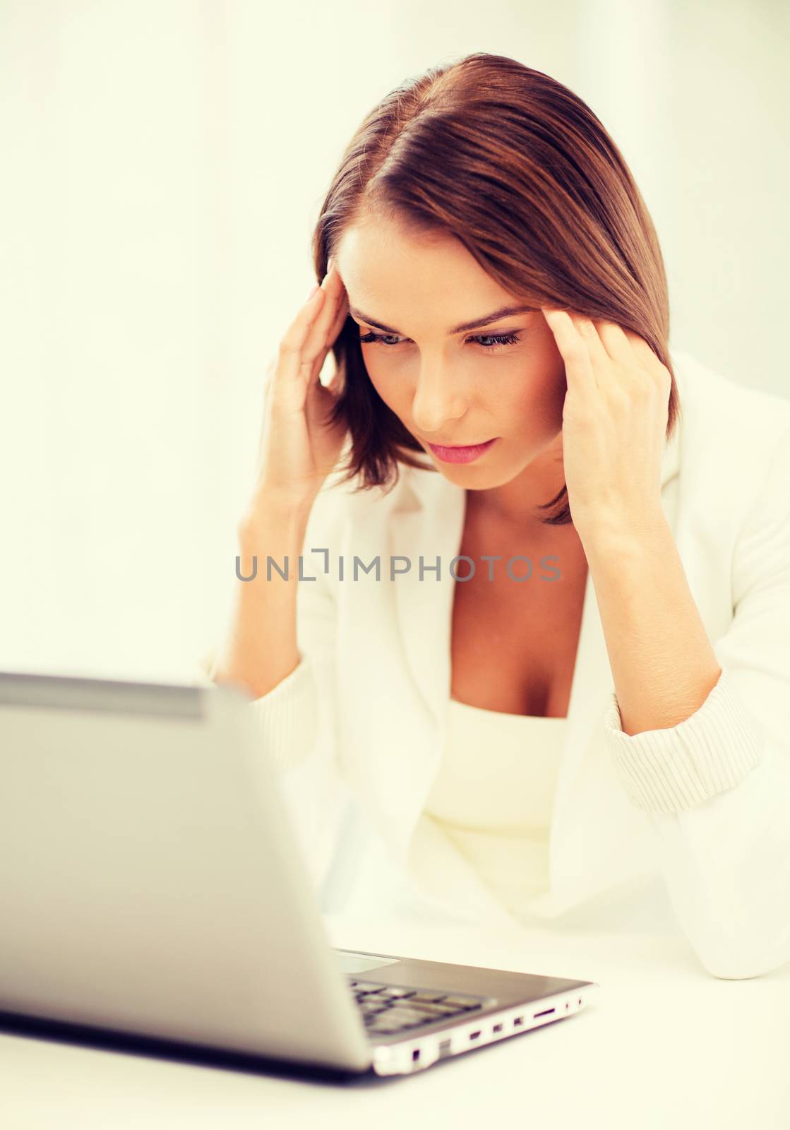 business, stress and technology concept - businesswoman with laptop in office