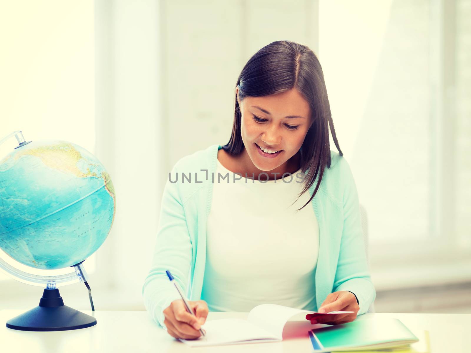 education and school, travel concept - female teacher with globe and notepad
