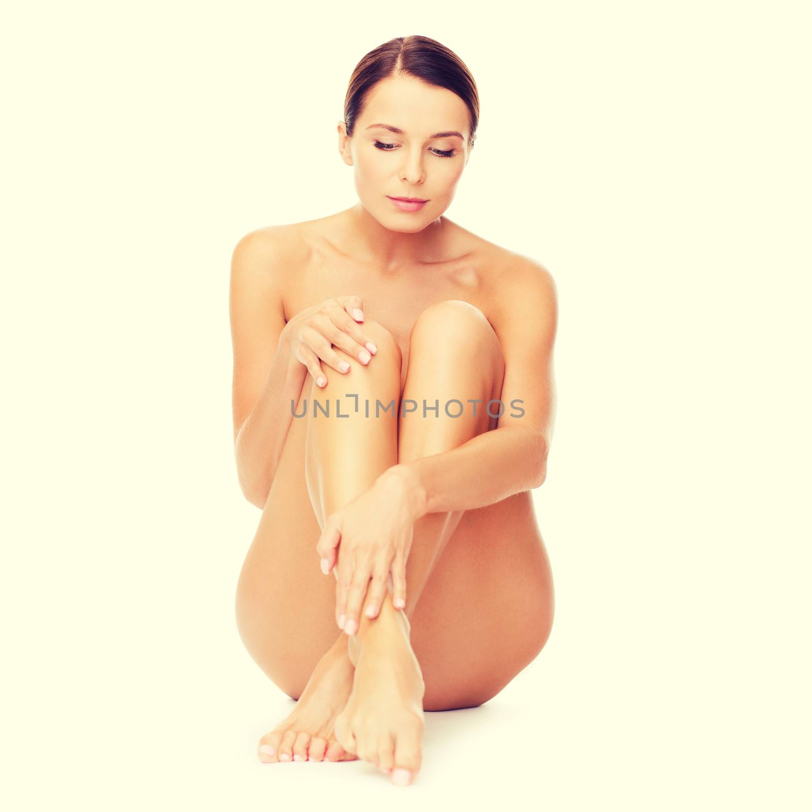 health and beauty concept - beautiful naked woman touching her legs