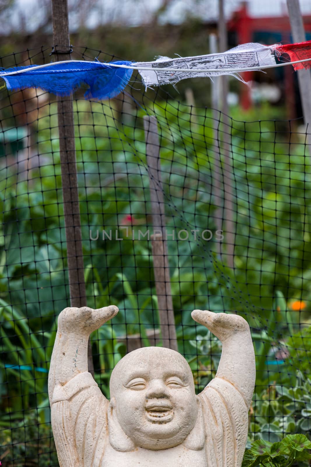 A statue of a Buddha with his arms over his head in joy.