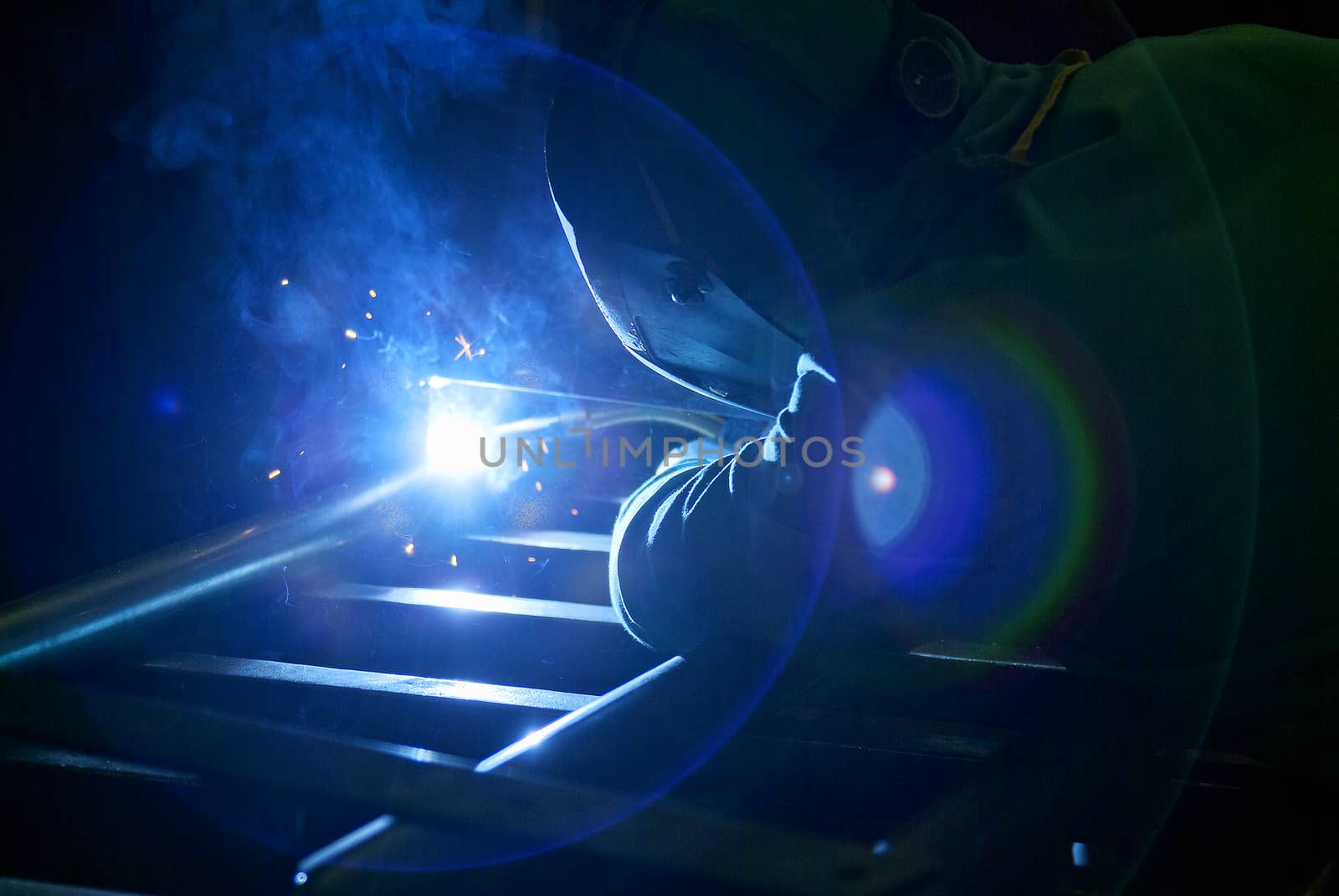 Industrial worker who performs welding and creates lighting effects