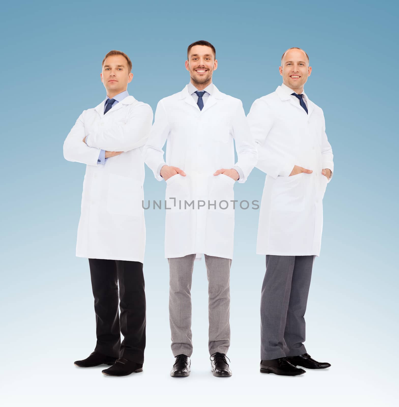 healthcare, profession, teamwork and medicine concept - group of smiling male doctors in white coats over blue background