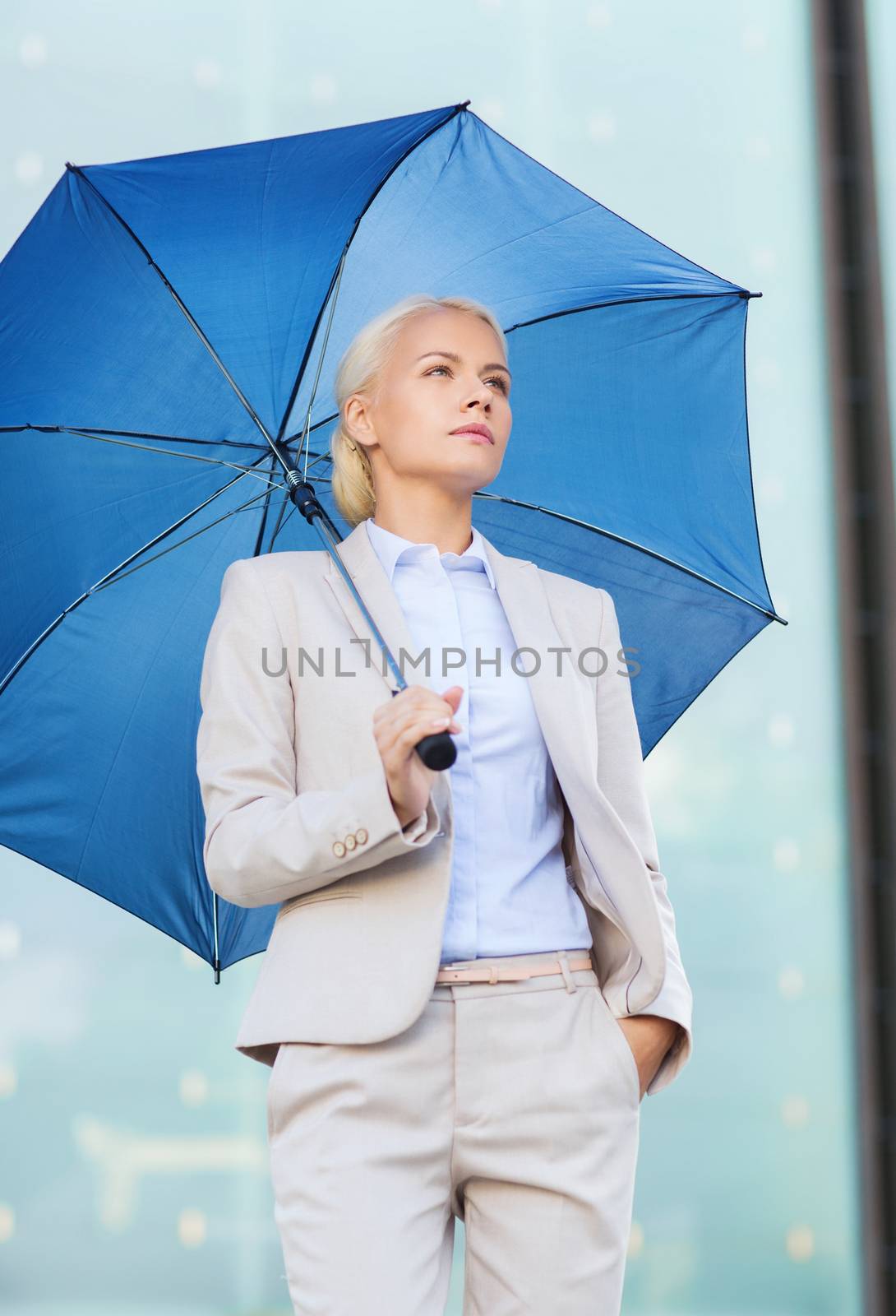 business, bad weather and people and concept - young serious businesswoman with umbrella outdoors