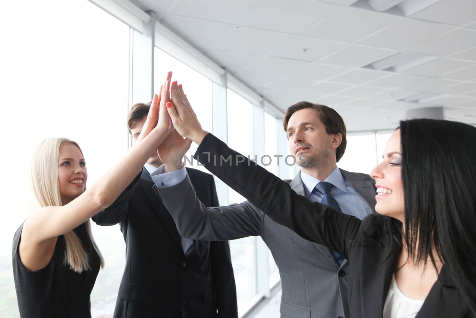 Happy business people hands giving high five 