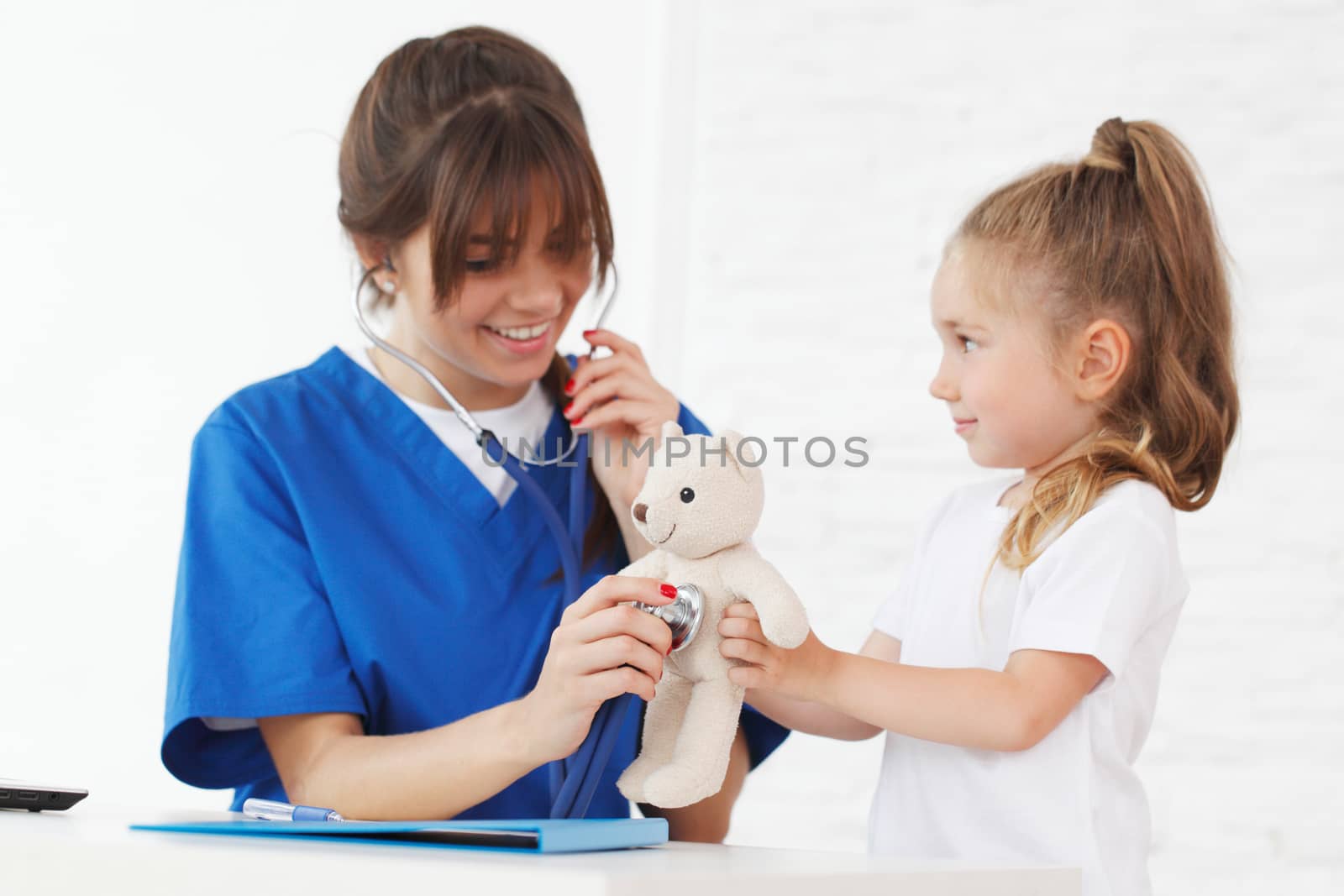 nurse and kid examining teddybear