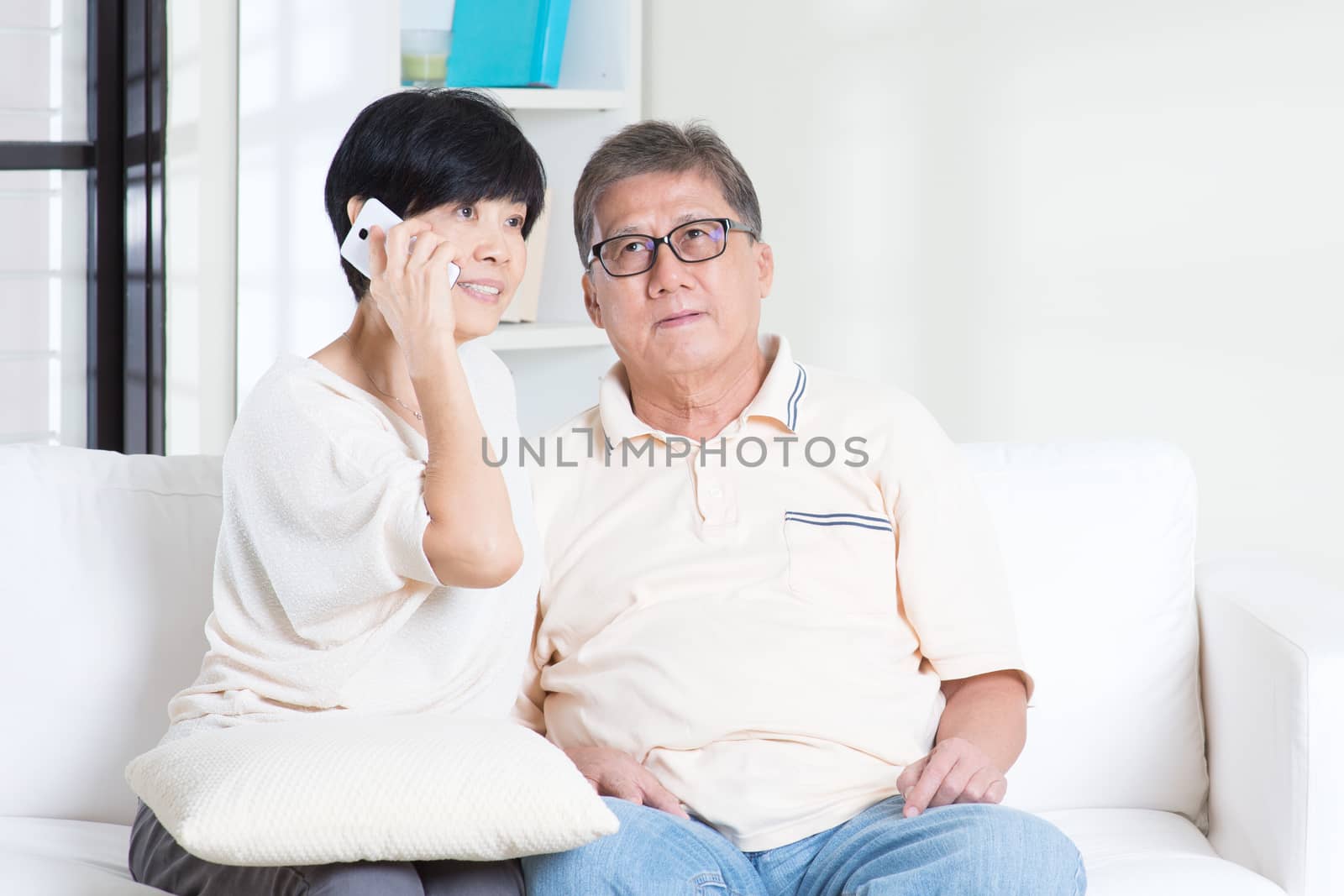 Asian senior couple calling on phone, using smartphone. Family living lifestyle at home.