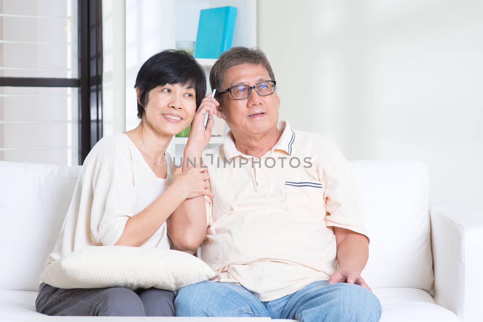 Modern technology, age and people concept. Mature Asian couple using smart phone. Family living lifestyle at home.