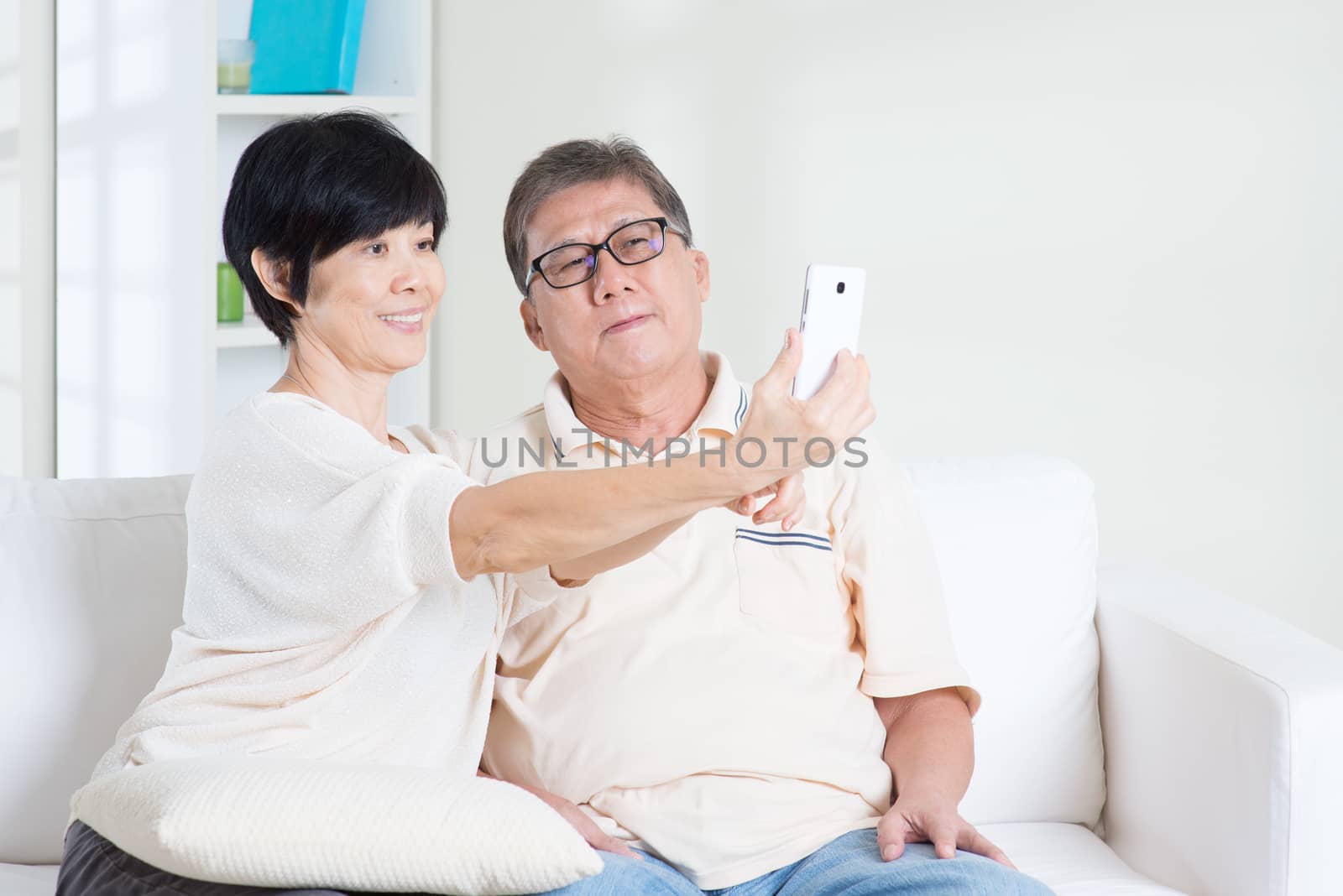 Senior using smart phone making selfie by szefei