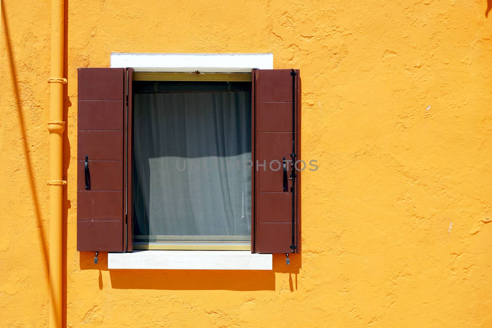 Brown Window in Burano on yellow color wall building architecture, Venice, Italy