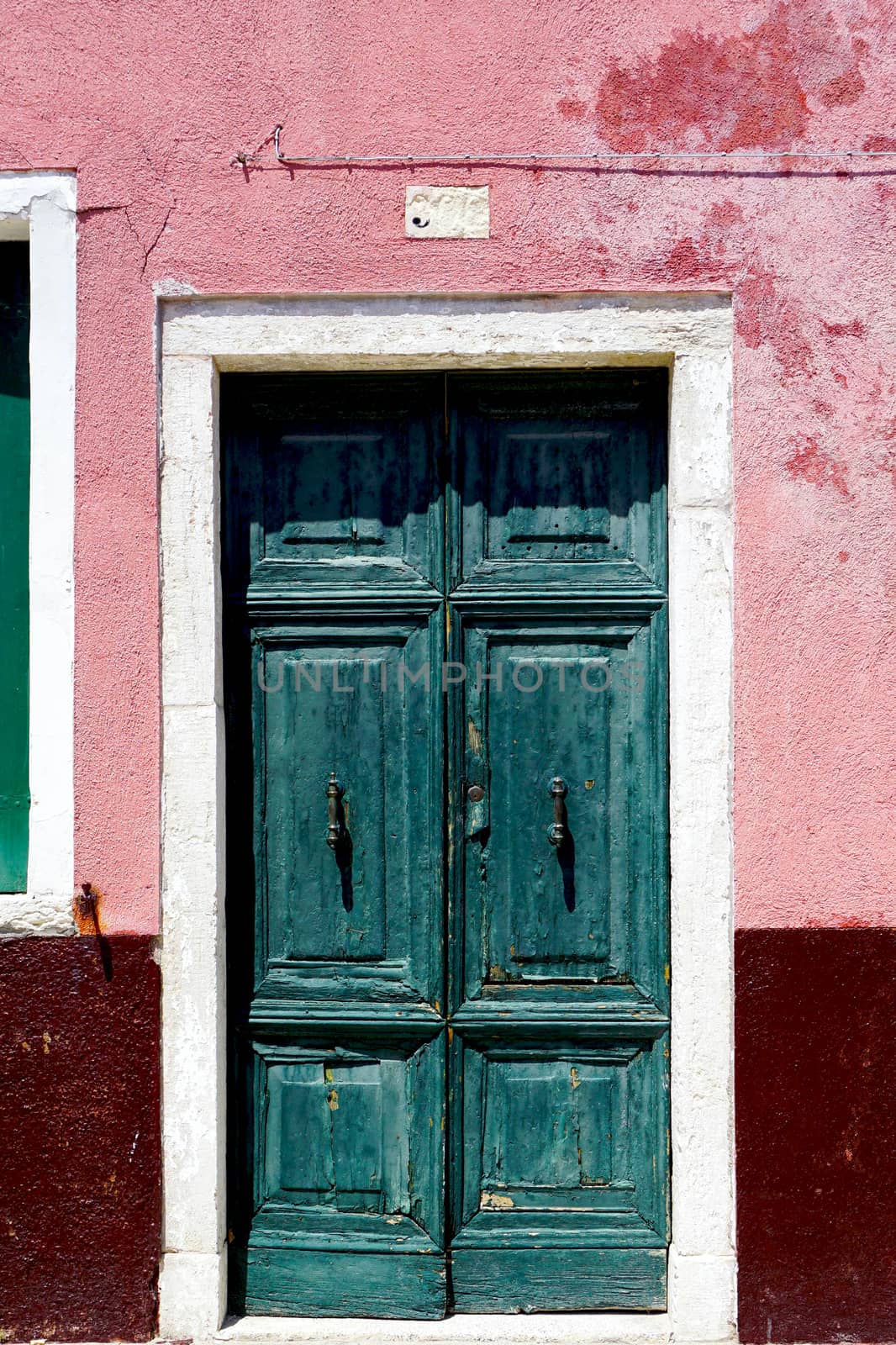 Old Door in Burano on colorful wall building architecture, Venice, Italy