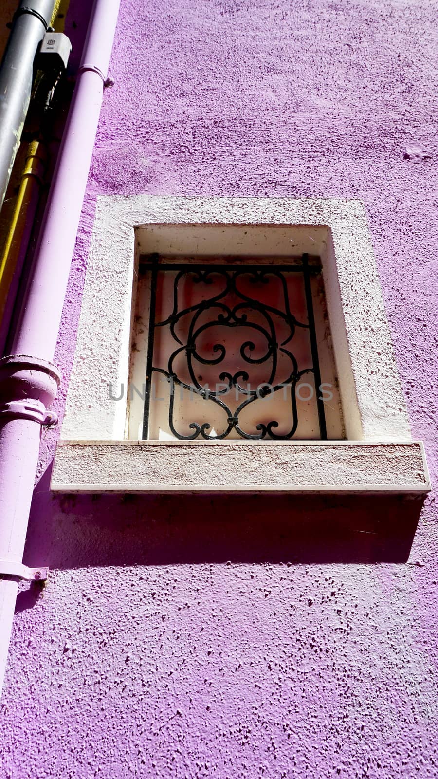 Window frame in Burano on purple color wall building architecture, Venice, Italy