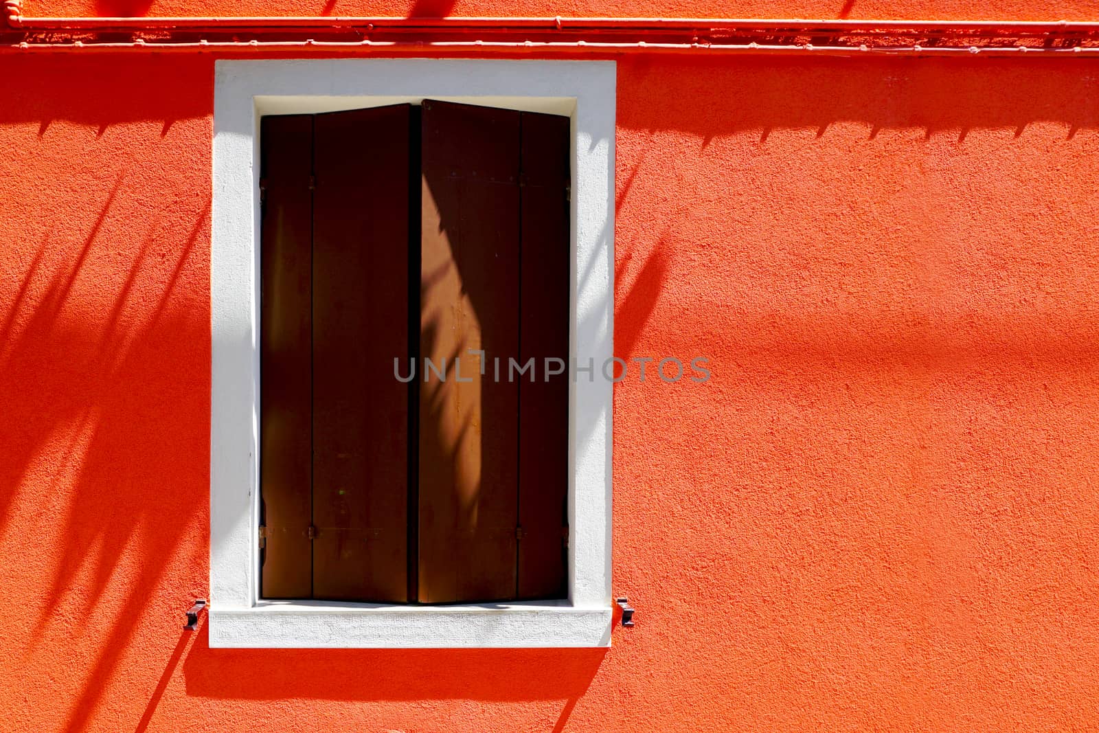 Window house in Burano on orange color wall building architecture, Venice, Italy