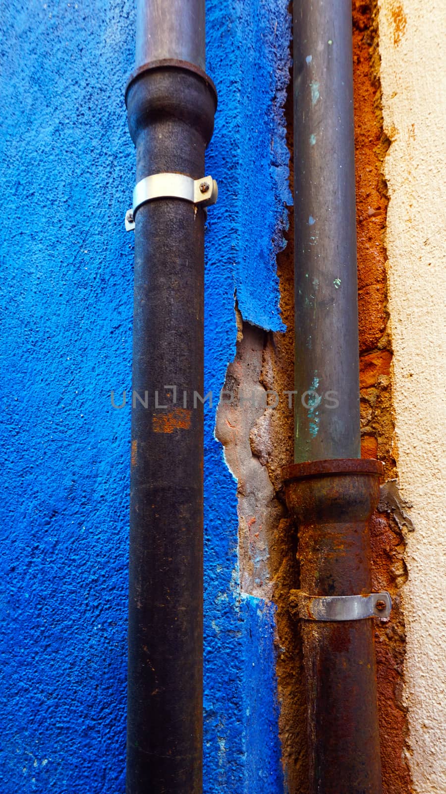rustic metal pipe on blue color wall in Burano, Venice, Italy