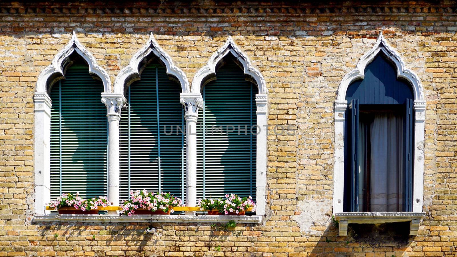 four windows in arch shape and ancient decay brick wall building architecture in Murano, Venice, Italy