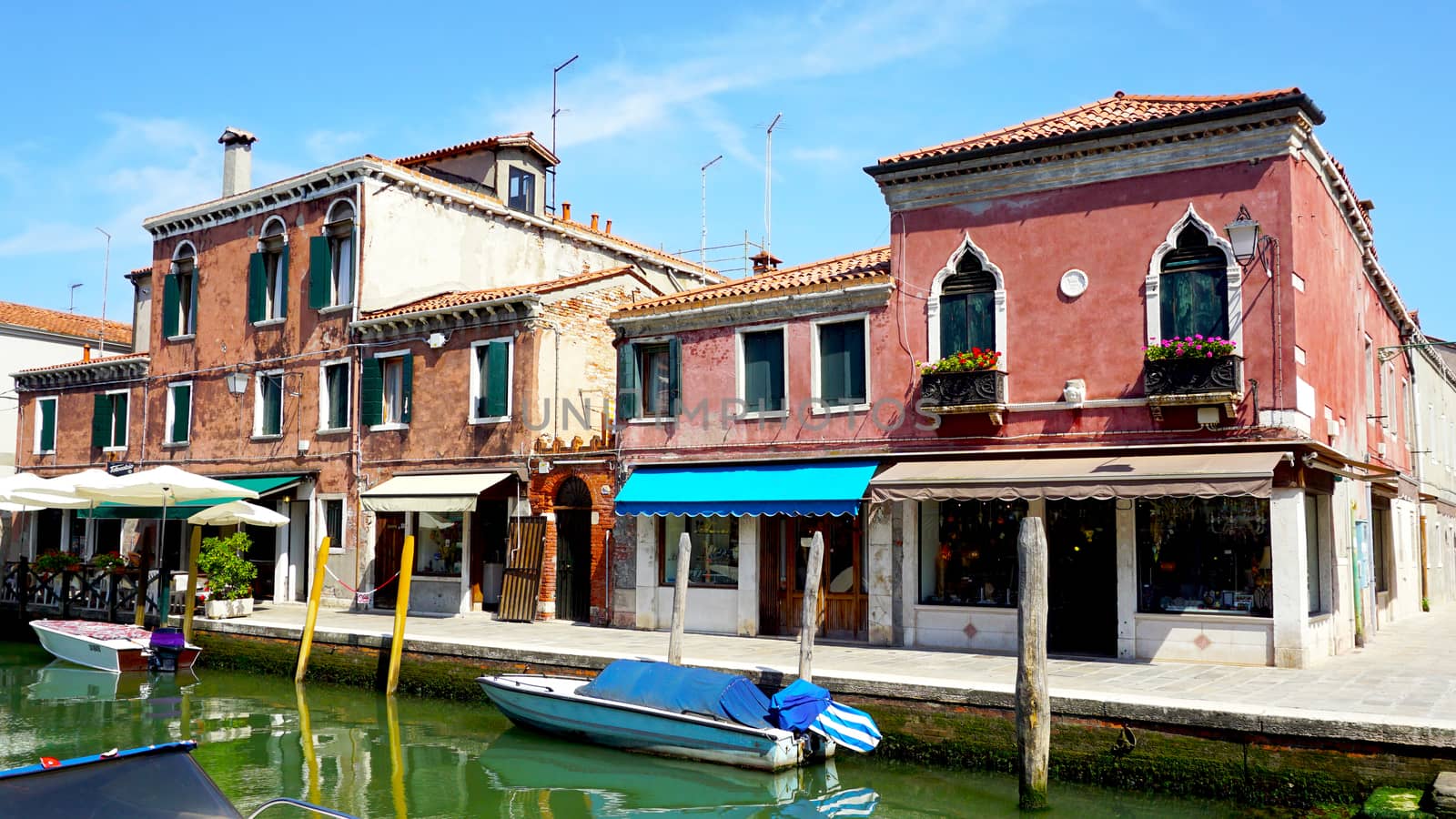 building architecture with canal and boat in Murano, Venice, Italy