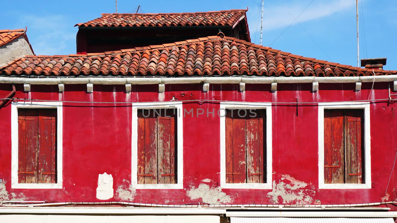 old window house and roof with red color wall architecture in Murano, Venice, Italy