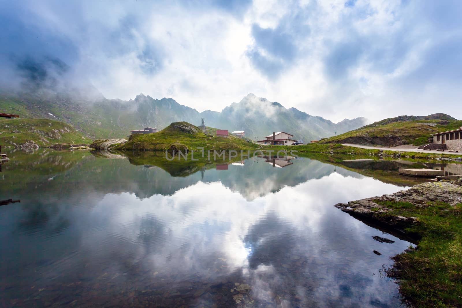 BALEA LAKE, ROMANIA - JUNE 24, 2012: Idyllic view with typical lodges on Balea Lake shore in Fagaras Mountains, Romania.