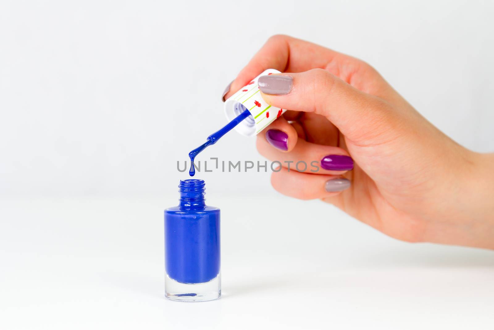 Blue nail polish drop on white background