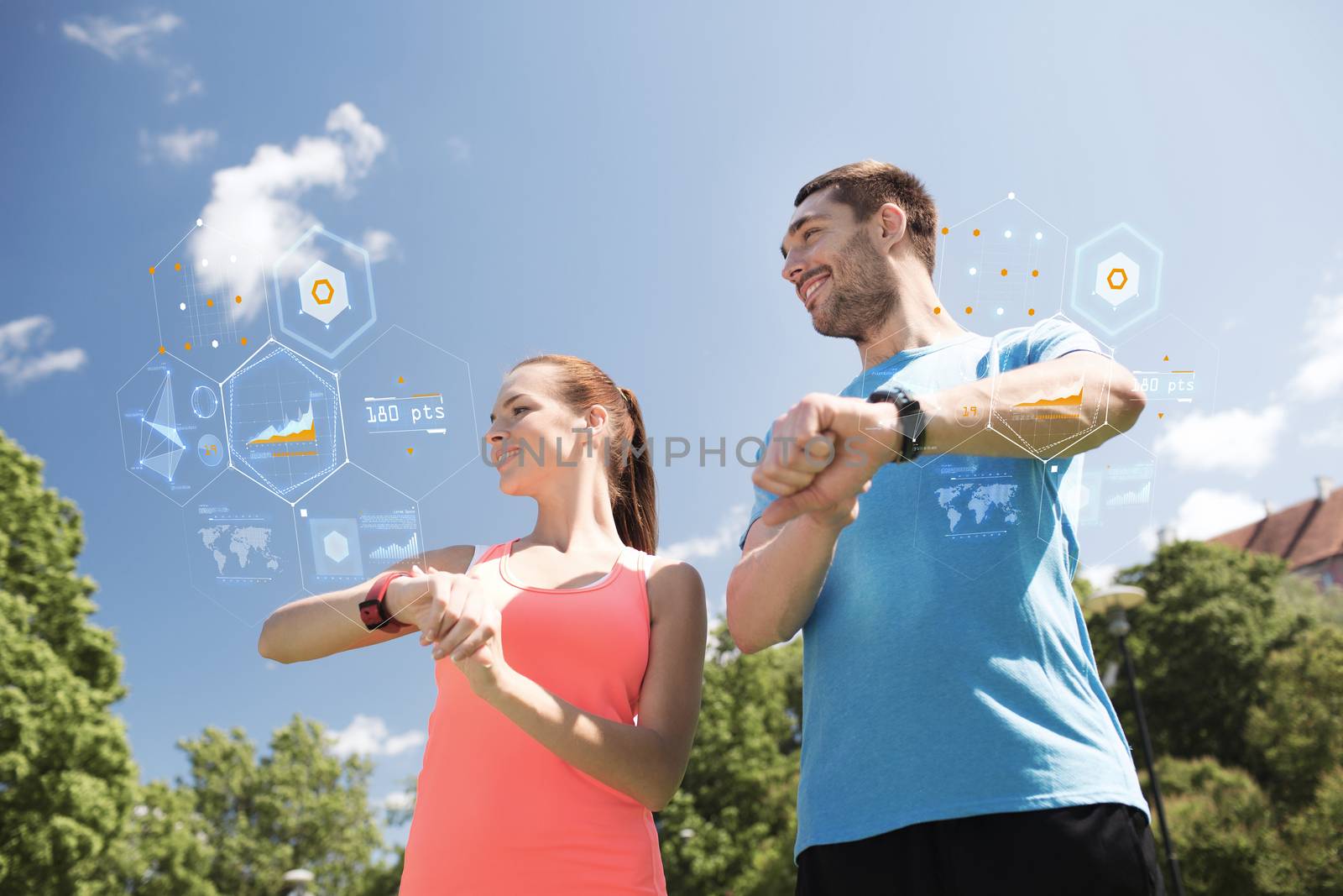 fitness, sport, training, technology and lifestyle concept - smiling couple with heart rate watches outdoors