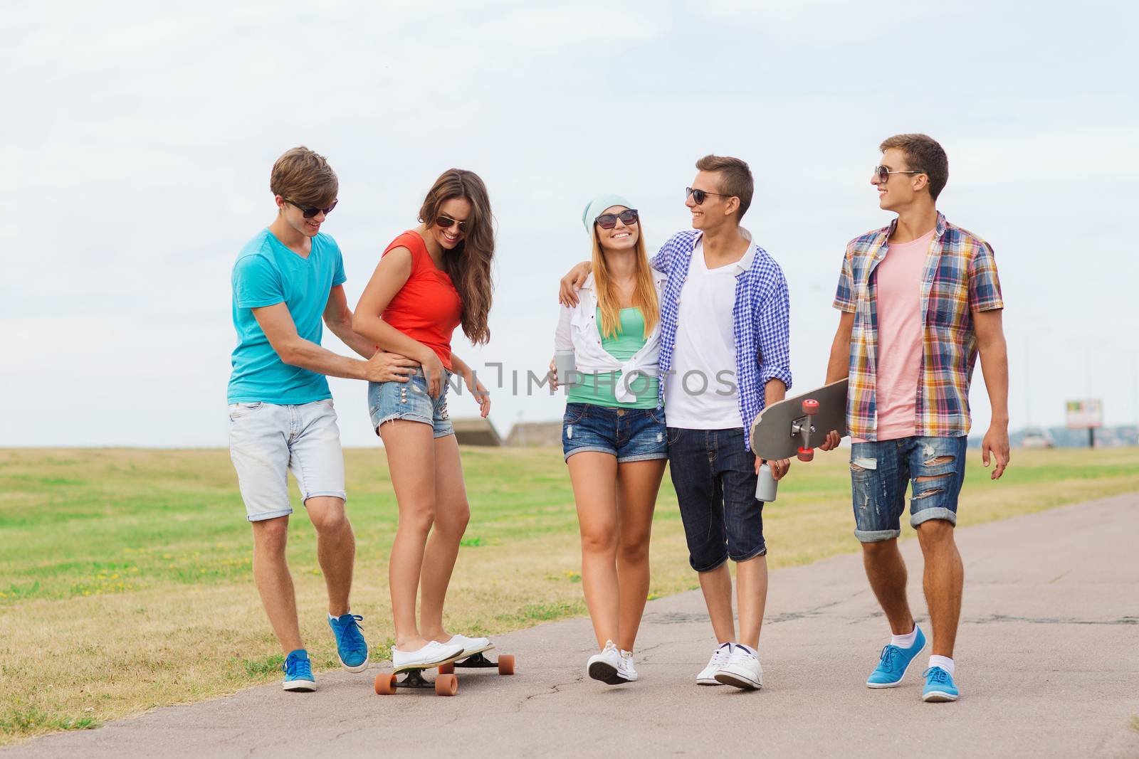 group of smiling teenagers with skateboards by dolgachov