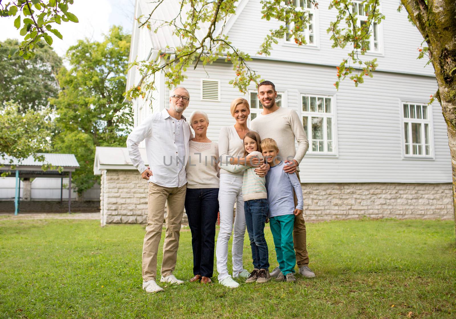 happy family in front of house outdoors by dolgachov