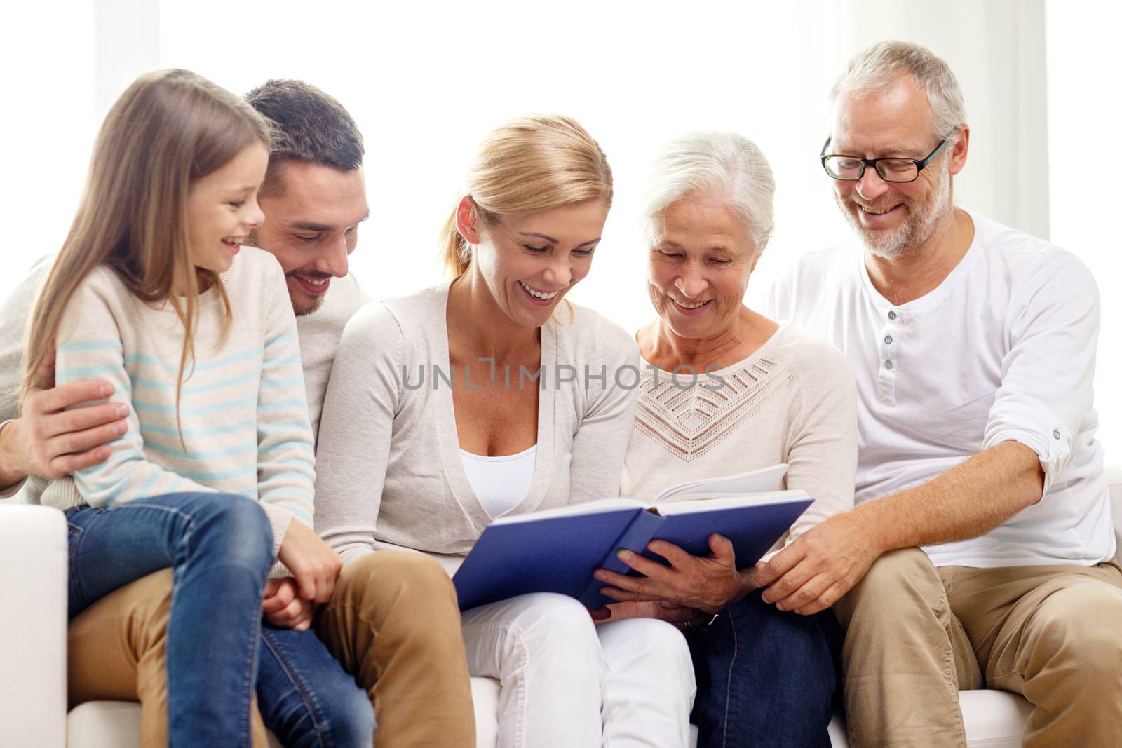 happy family with book or photo album at home by dolgachov