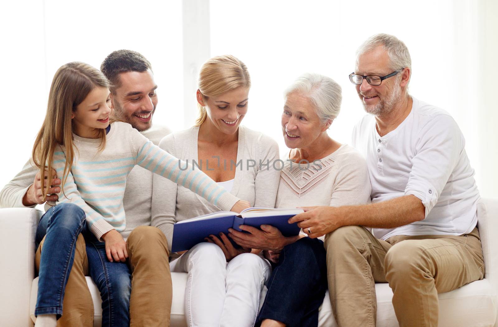 happy family with book or photo album at home by dolgachov
