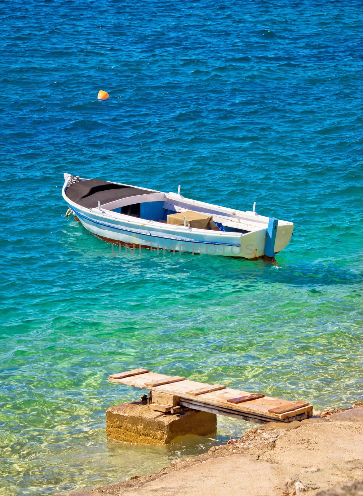 Old wooden fishermen boat on turquoise beach, Mediterranean sea