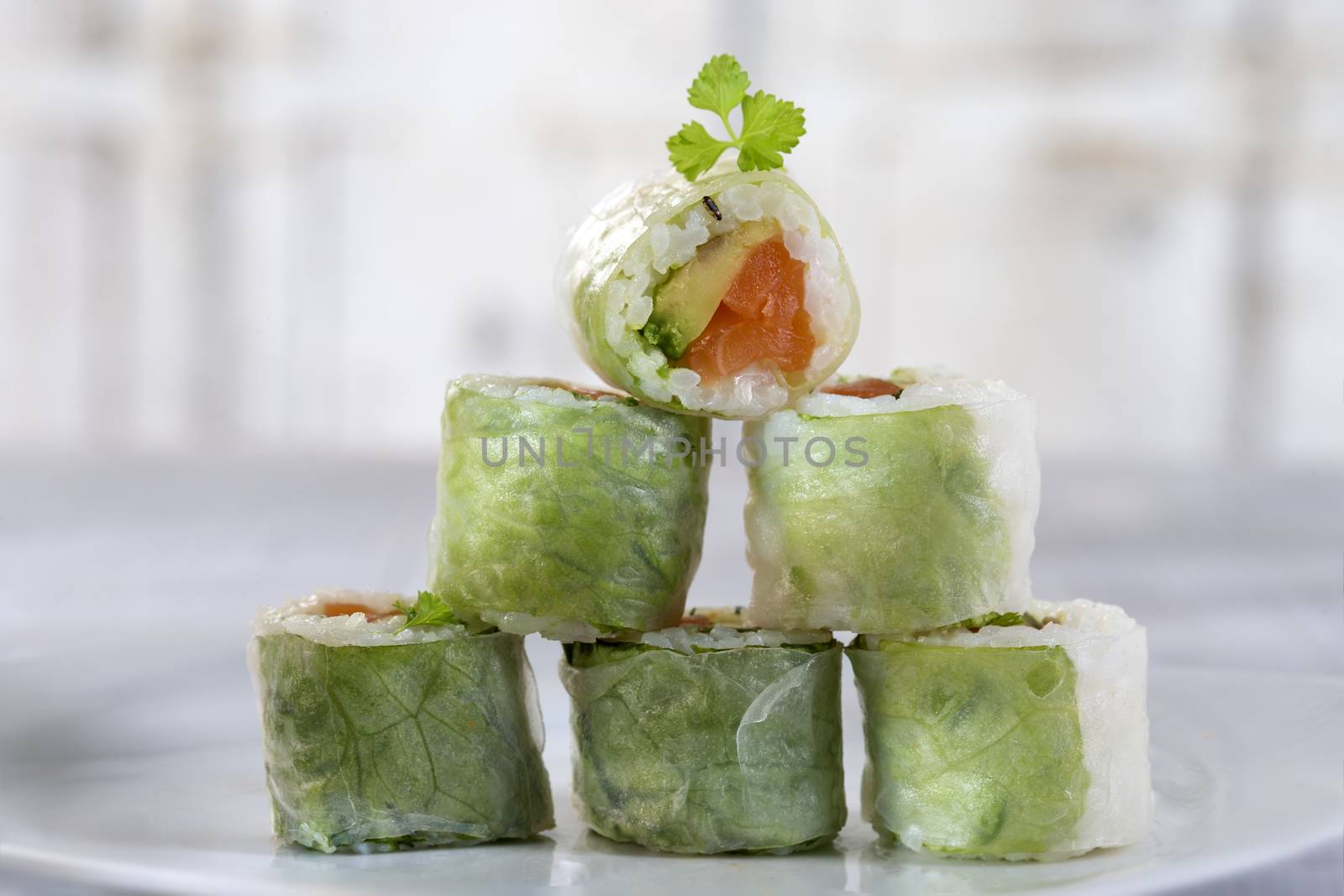 Delicious sushi rolls on white plate with chopsticks and wasabi