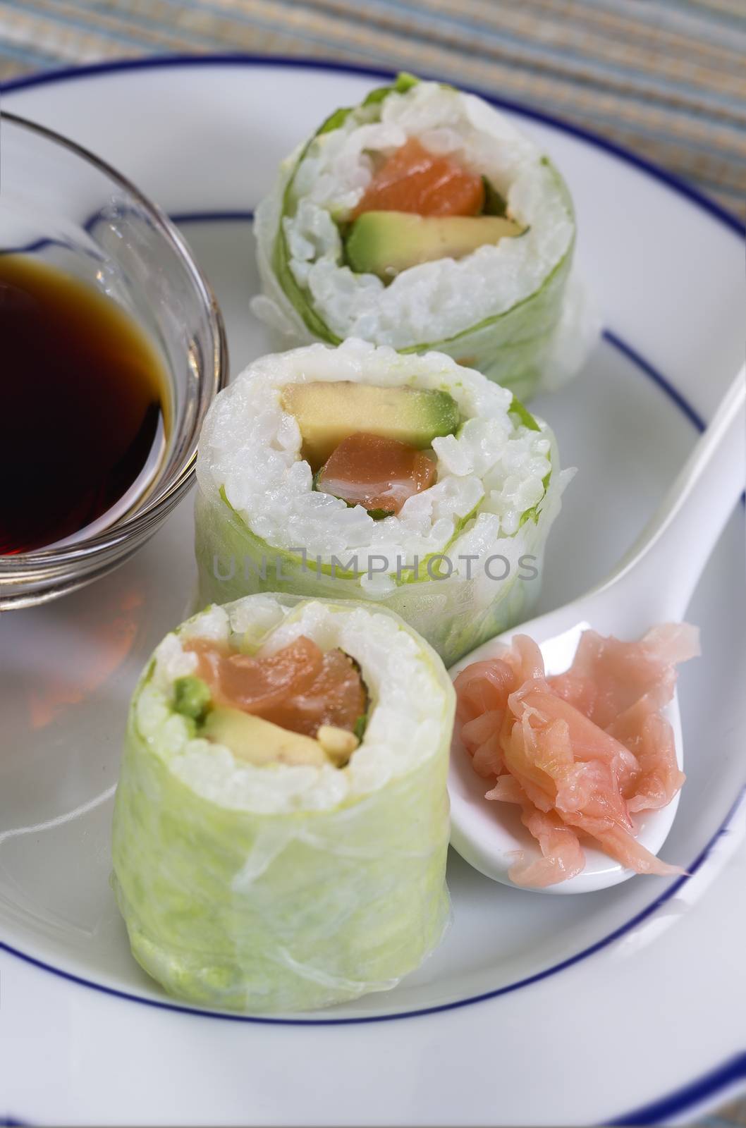 Delicious sushi rolls on white plate with soy sauce