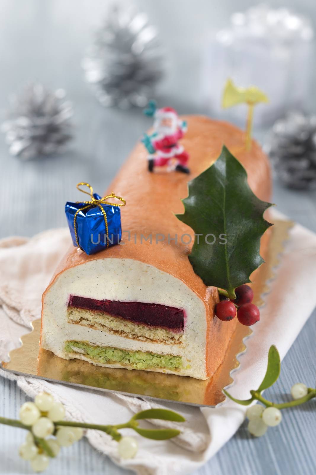 Yule log of white chocolate mousse, stuffed with raspberry puree sponge rolls, glazed with raspberry jelly