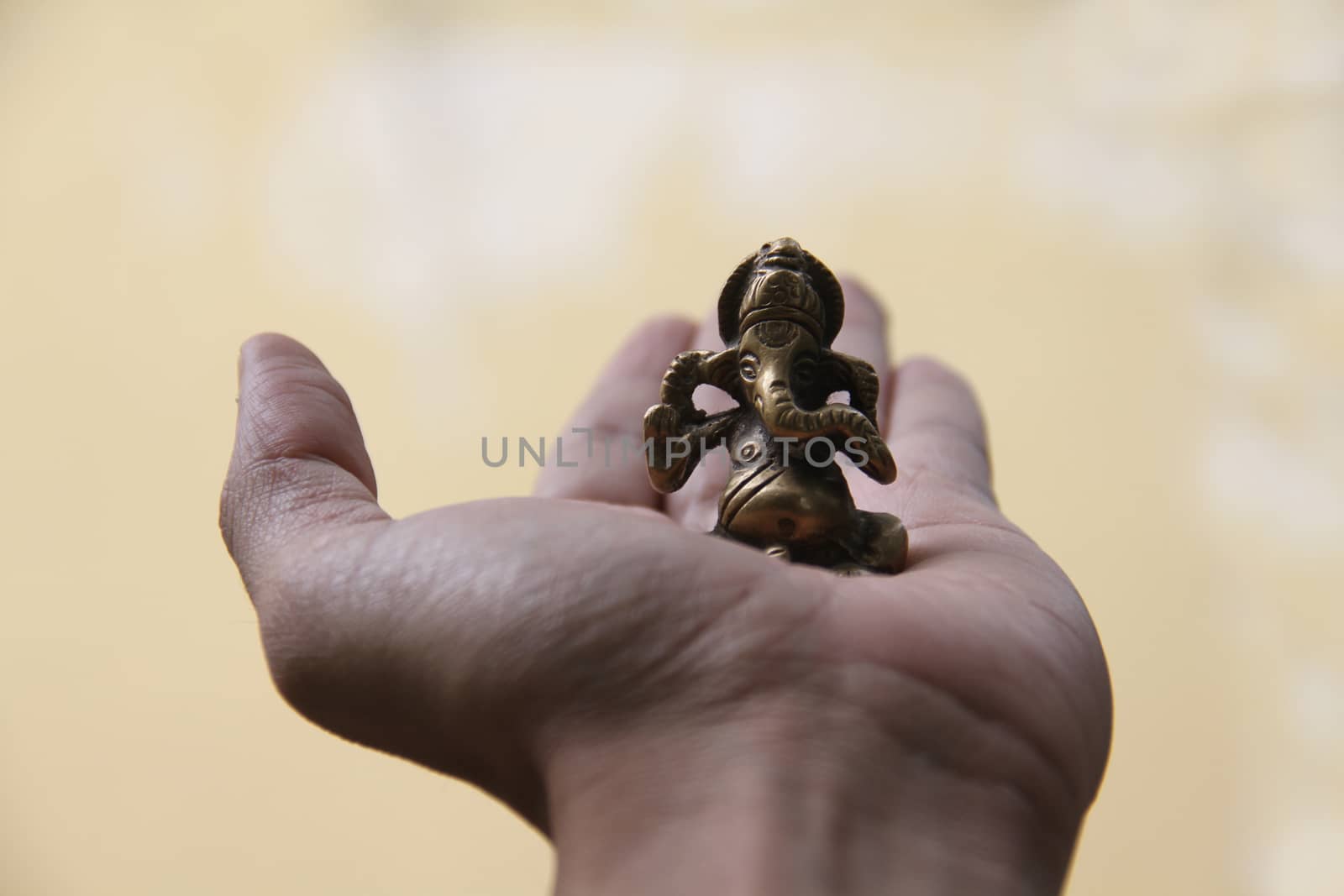 A beautiful antique brass idol of lord Ganesha held in the hand for luck