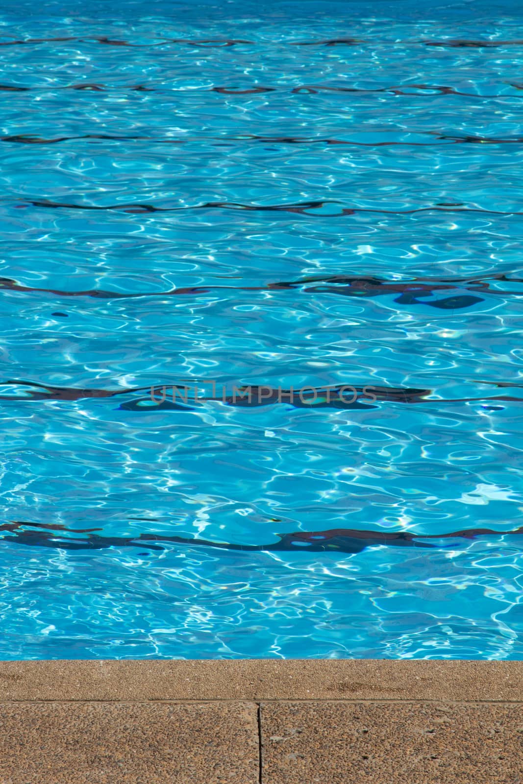 Blue pool water with sun reflections