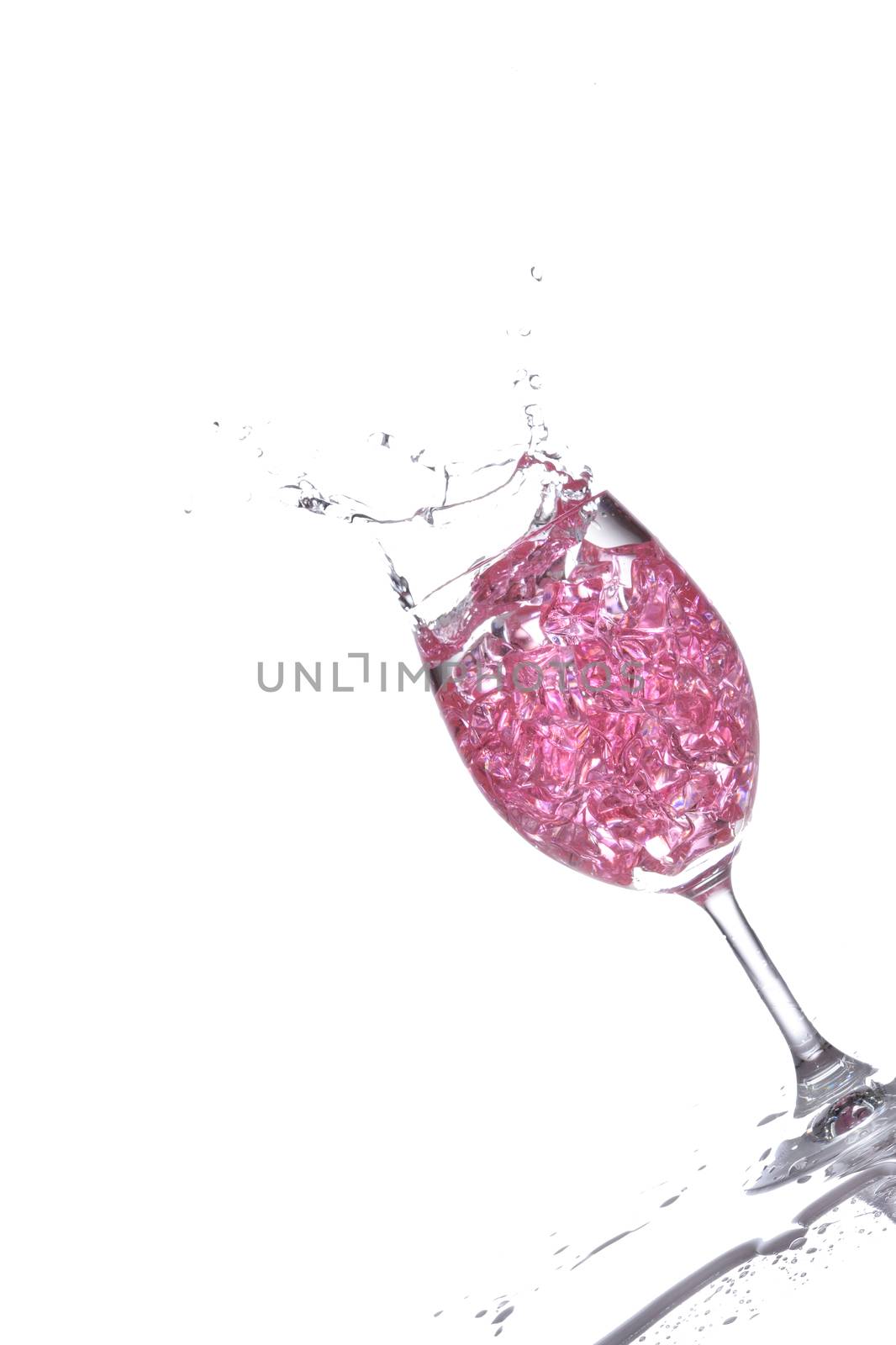 Stemmed champagne glass with liquor splashing out, isolated on white background