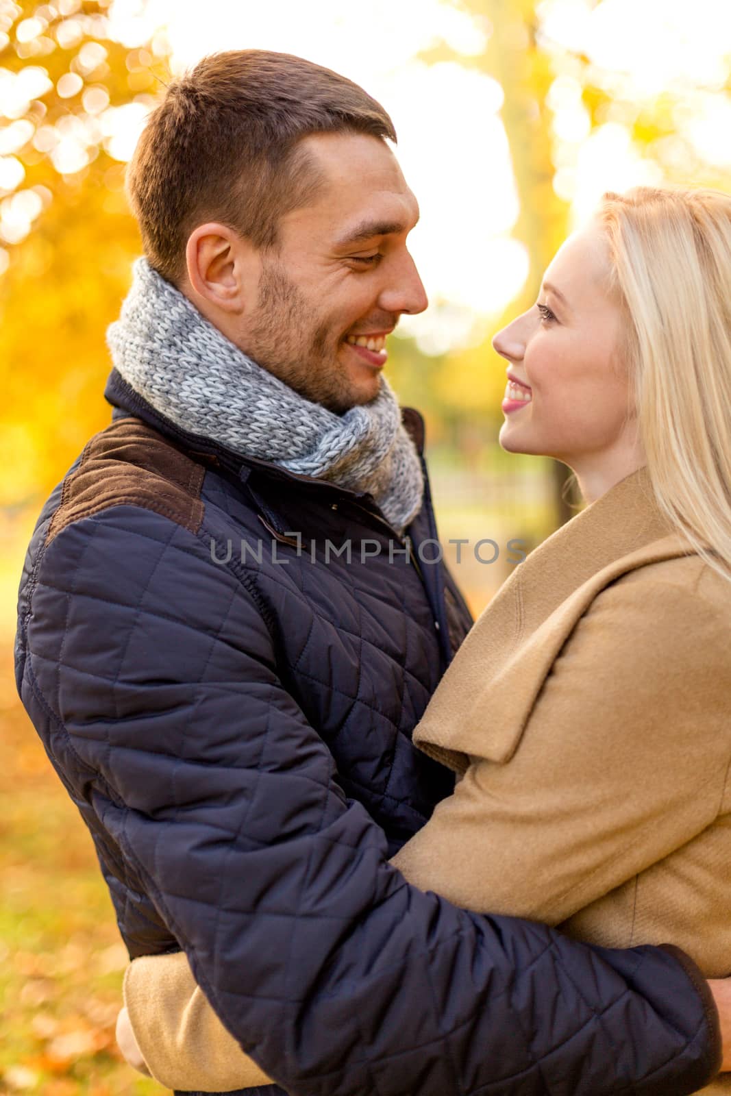 smiling couple hugging in autumn park by dolgachov